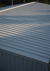 Obraz premium Corrugated metal roof architectural detail in sunlight and shadow play