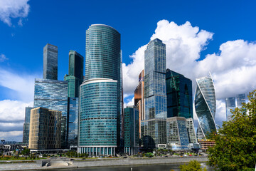 Modern skyscrapers rise against a clear blue sky in a bustling urban landscape during the day