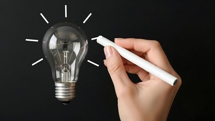 Hand drawing light bulb with chalk.