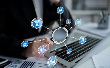 A business professional engages with digital technology, showcasing various icons that represent success, data analysis, and strategic planning in a modern office setting. Crux