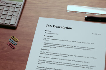 A dummy document of the Job Description is on the desk, along with a calculator and a pen.