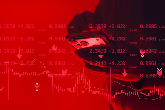 Hand holding smartphone with trading data and falling market charts on red background. Concept of financial crisis, stock market crash, crypto trading loss and investment risk. - Powered by Adobe