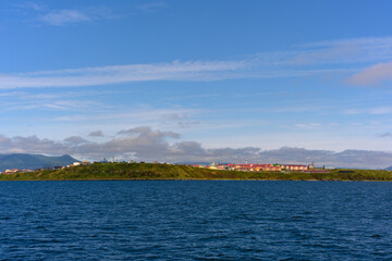 Serene landscape of a coastal town under a clear blue sky at midday