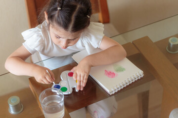 Niña mezclando colores con acuarelas