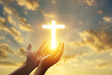 Human hands open palm up worshiping a glowing Christian cross in sunset sky. Concept for faith, spirituality, and hope.