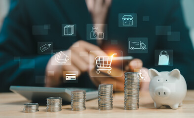 Businessman using smartphone with shopping cart icon, piggy bank and coins stack. Concept of online shopping, e-commerce, and financial saving plan.