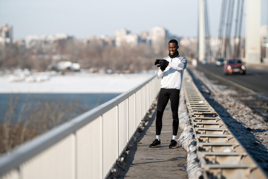 Male athlete checking smartwatch on winter bridge - Powered by Adobe