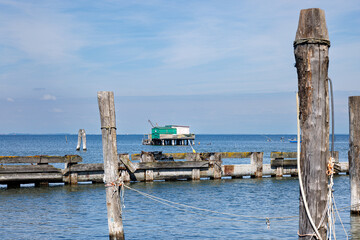 A rustic wooden stilt house and boat with fishing nets
