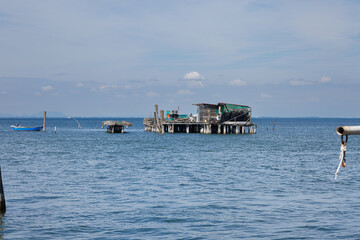 A rustic wooden stilt house and boat with fishing nets