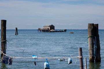 A rustic wooden stilt house and boat with fishing nets