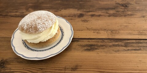 Swedish semla bun with whipped cream on vintage plate – traditional pastry for Fettisdagen...