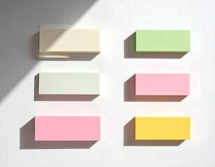 Obraz premium Overhead shot of six colorful rectangular sticky notes casting distinct shadows on a white surface, with light play