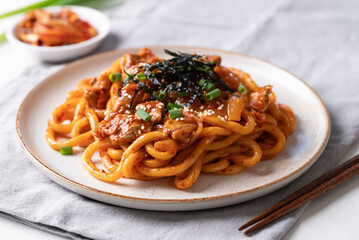 Stir fried Udon noodle with kimchi cabbage, pork, spring onion, sesame seed and seaweed on top