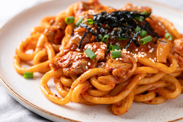 Stir fried Udon noodle with kimchi cabbage, pork, spring onion, sesame seed and seaweed on top