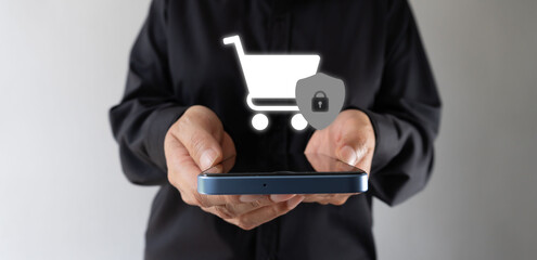 Businesswoman holding a cell phone with a shopping cart icon and shield. Secure shopping.