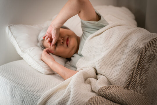 Senior woman unable to fall asleep in the bedroom (falling asleep, uncomfortable sleep, insomnia, quality of sleep)