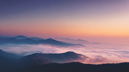 Fototapeta premium A breathtaking view of mountains shrouded in mist during a colorful sunset, offering a serene and tranquil atmosphere.