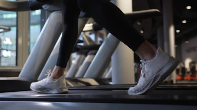 Sneakers feet. Sportsman running on treadmill in gym. Treadmill workout in fitness gym. Exercise cardio. Sport man feet do sport. Sportsman has cardio workout to burn calories. Gym treadmill