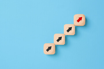 Ladder of success in business growth concept, Wooden blocks stacking as step stair with arrow up on blue background, copy space