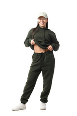 Naklejka premium Young woman in khaki sports suit with cap on white background