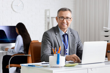Male business analyst working with laptop at desk in office. Data science concept
