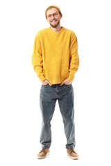 Fototapeta premium Young man in yellow sweater with hat and eyeglasses on white background