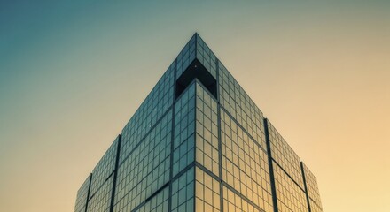 Modern office building facade tapers dramatically against a colorful twilight sky