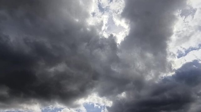Un  cielo de azul con varias nubes  de color blanco y gris con un movimiento lento. Clima.