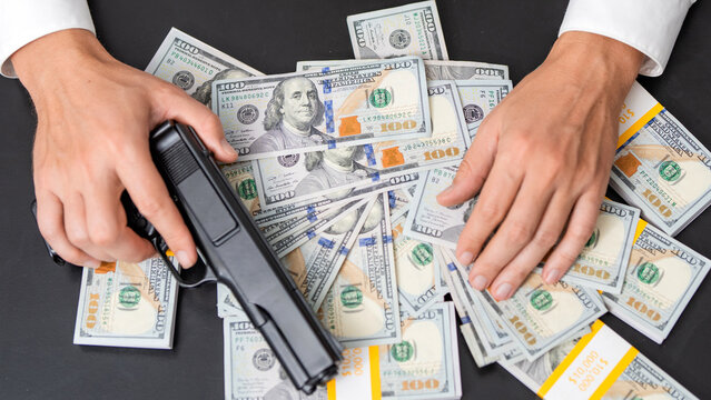 Robber with gun taking money. Criminal taking money. Armed robber crime deal. Thief killer do robbery, mafia. Gun with money. Criminal crime theft. Hand with gun and dollar banknote currency, deal