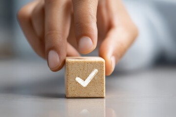 Human finger placing a wooden block with a checkmark icon symbolizing completion and approval.