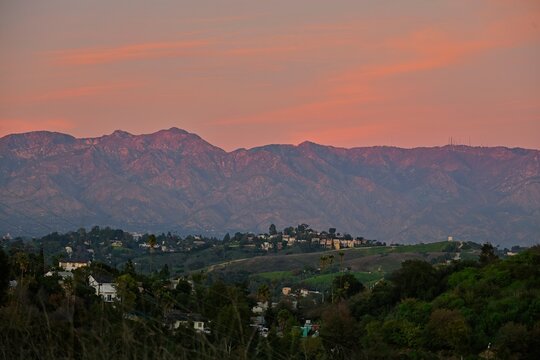 Whispy clouds glow pink in the light of the sunset over Los Angeles
