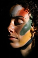 A portrait where red, yellow, black, and white light projections softly overlap across a person face, representing unity among all races