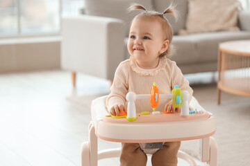 Cute little baby girl with walker at home