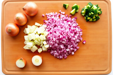 Fresh Chopped Vegetables on Wooden Cutting Board for Healthy Meal Preparation. Vibrant Diced Onions, Potatoes, and Peppers Ready for Cooking.