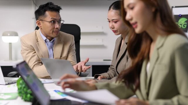Asian business professionals collaborating on a corporate project about ESG principles, sustainable and ethical strategies.