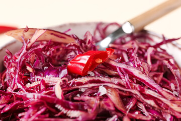 Fototapeta premium Bowl of tasty red sauerkraut with chili pepper slice, closeup