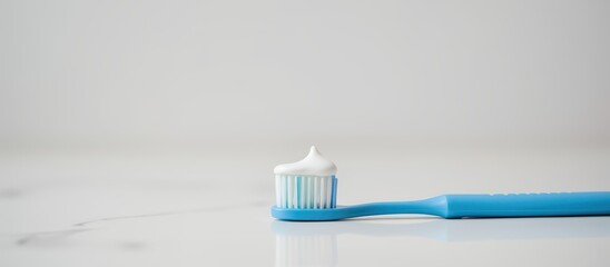 Toothbrush with toothpaste on a clean surface against a minimalist background.