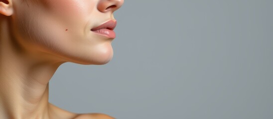 Naklejka premium Profile of a woman with smooth skin against a neutral background.