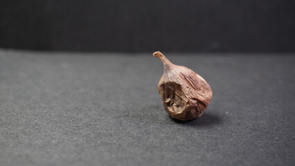 Peeled Clove of Fermented Black Garlic Allium sativum on Dark Table