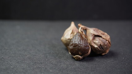 Fermented Single Clove Black Garlic, Allium sativum on Dark Background