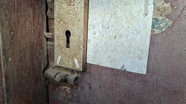 rusty hinge lock attached to a wooden door