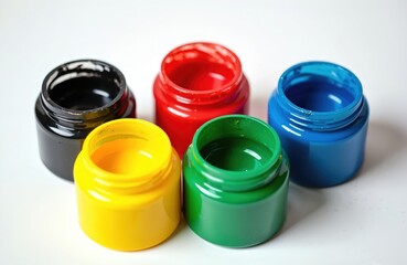 Five open plastic jars of vibrant paint in black, red, yellow, green, blue on white. Bright containers for children art, crafts, education, creative projects. Gouache paint pots for school, hobby