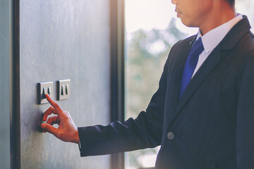 Man turn off on light switch at the wall. Energy saving concept. Selected focus