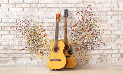 Two guitars near brick wall