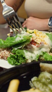 Woman Eating Healthy Salad with Quinoa at Restaurant Table