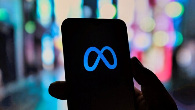Meta infinity logo on smartphone screen in city lights