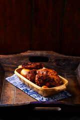 Fried chicken wings with potatoes on a rustic background. Soft focus.