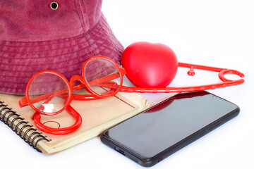 Collection of red heart, hat, coat hanger, and notebook on white background, simple flat layout.