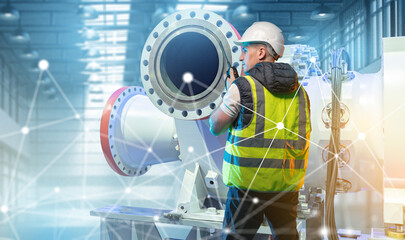 Industrial engineering, maintenance technician inspects pipeline equipment using digital monitoring to ensure safe operation in a smart manufacturing facility.