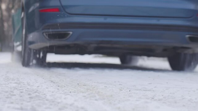 Close up of car tire on snow covered winter road. Concept of winter driving, road safety and traction